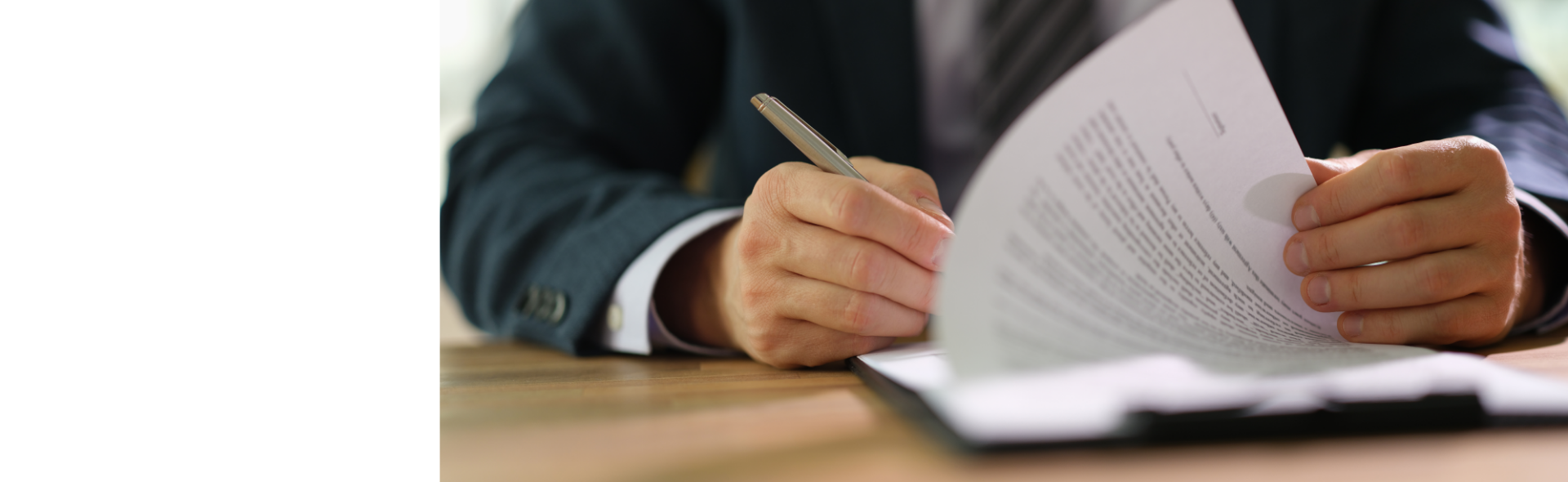 Person filling out employee contract paperwork at desk